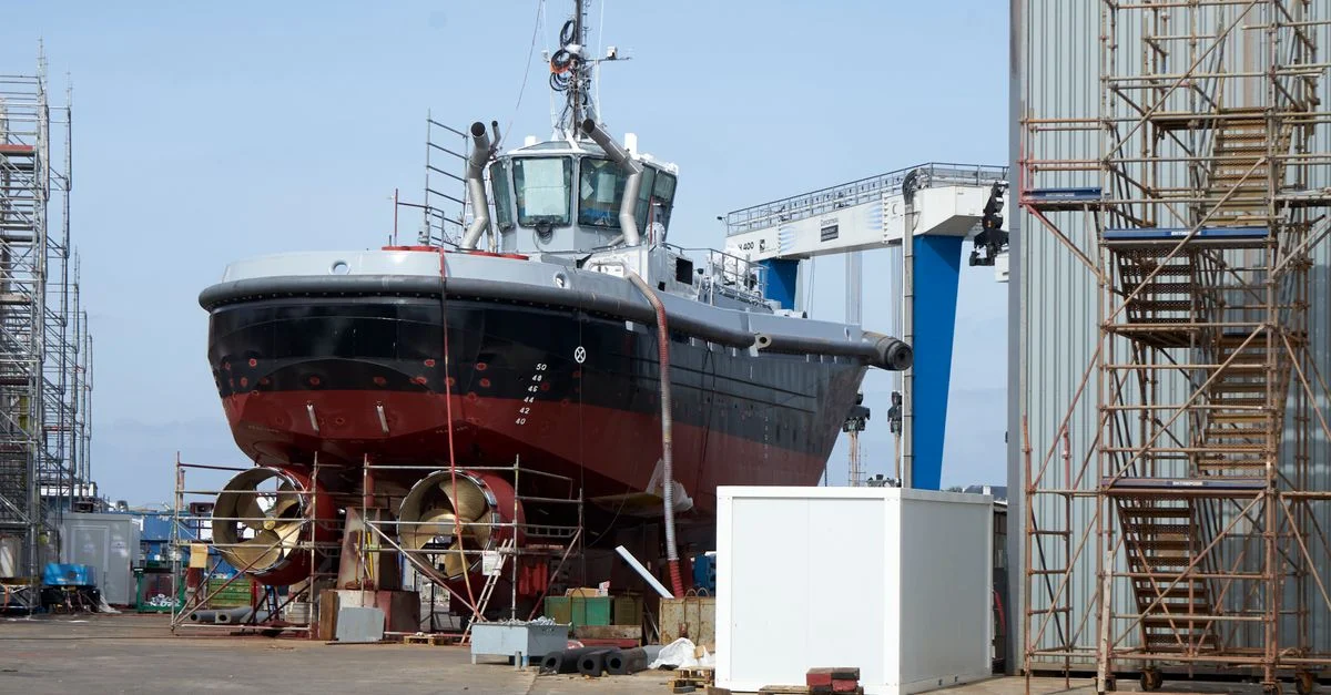 Un grand bateau en réparation dans un environnement industriel de dock. Parfait pour les thèmes liés à l'industrie maritime.