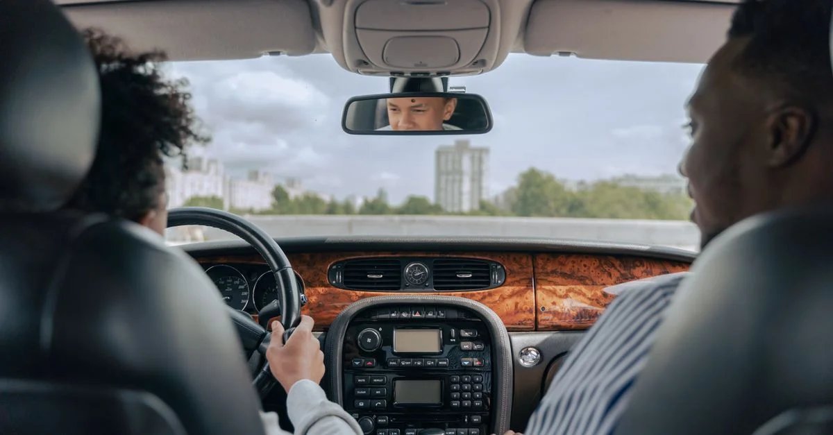 Père et fils se liant d'amitié en conduisant, montrant le guidage et la convivialité à l'intérieur d'une voiture.